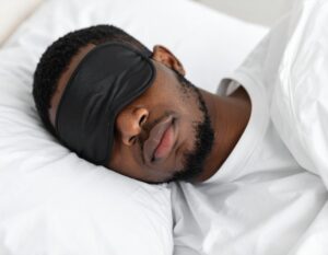Firefly_Close-up Of A Young African Man Sleeping With Dark Sleep Mask 171457